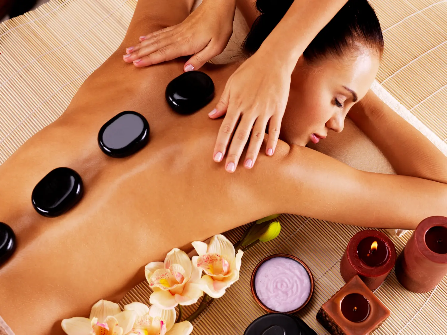 Erwachsene Frau bei einer Hot-Stone-Massage im Spa-Salon